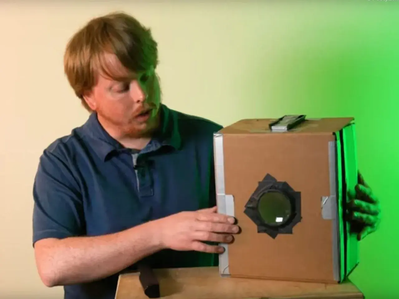 Mężczyzna pokazuje, jak zrobić camera obscura z kartonu. Prosty projekt DIY.