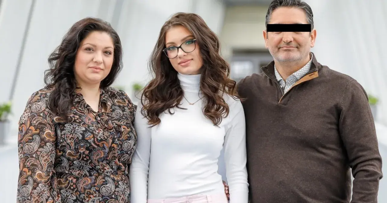 Rodzice Viki Gabor, mama z kręconymi włosami i tata z zasłoniętymi oczami, stoją obok córki w okularach.