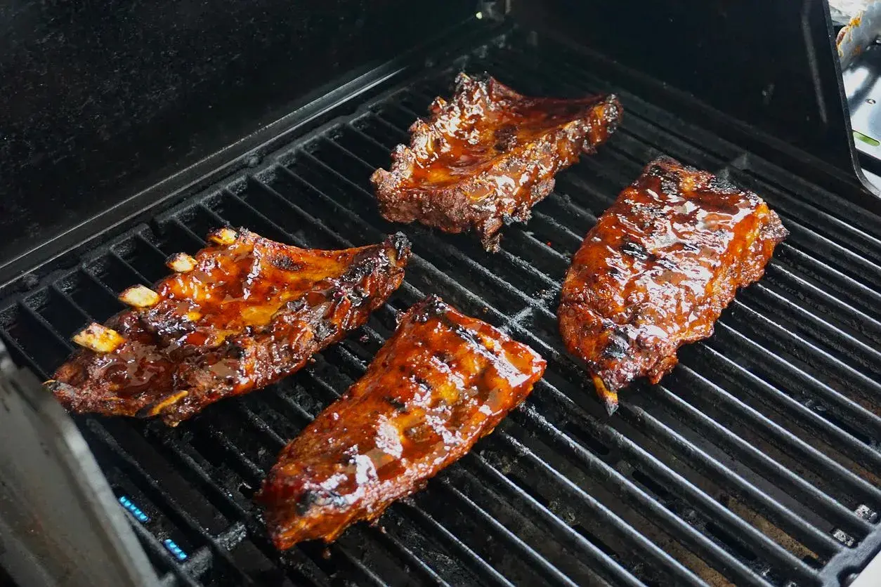 Soczyste żeberka w sosie barbecue grillują się na ruszcie. Idealne do marynowania w domowych sosach.