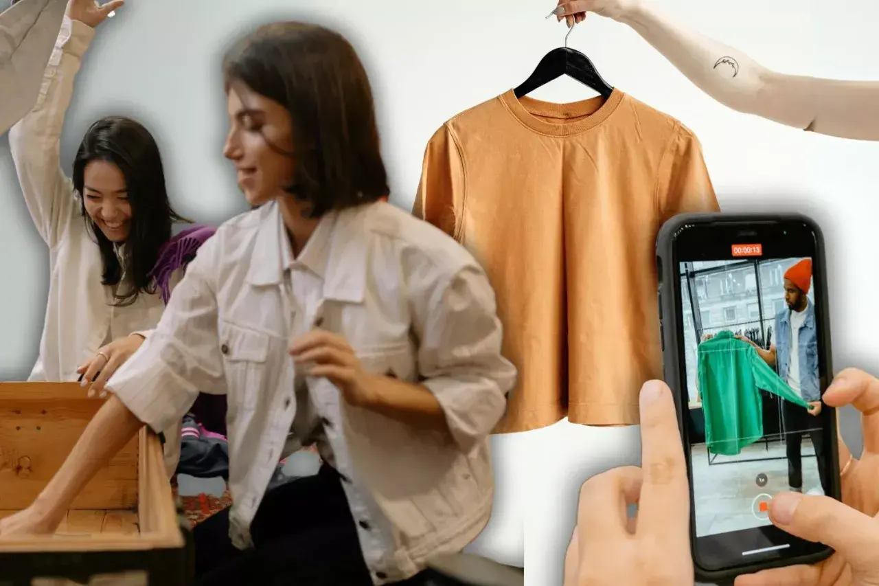 Chicas organizando ropa para vender por internet. Una camiseta naranja cuelga de una percha y un móvil graba a un hombre mostrando una prenda verde.