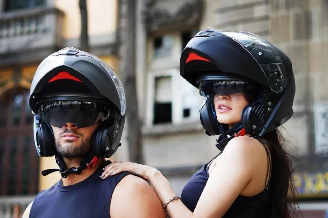 Pareja lista para rodar con sus cascos modulares, ofreciendo protección y estilo.