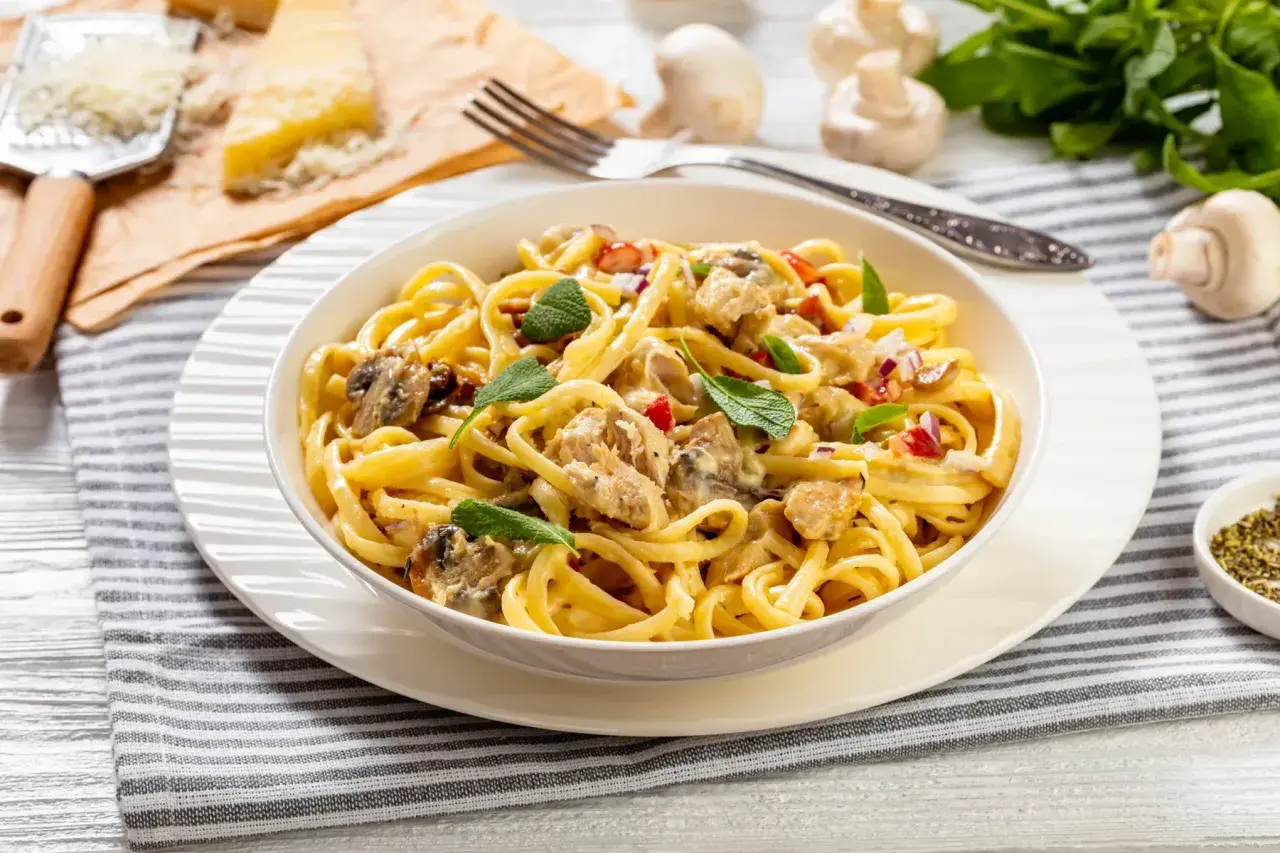 Un plat de pâtes crémeuses, un délice "one pot pasta" avec poulet, champignons et herbes fraîches.