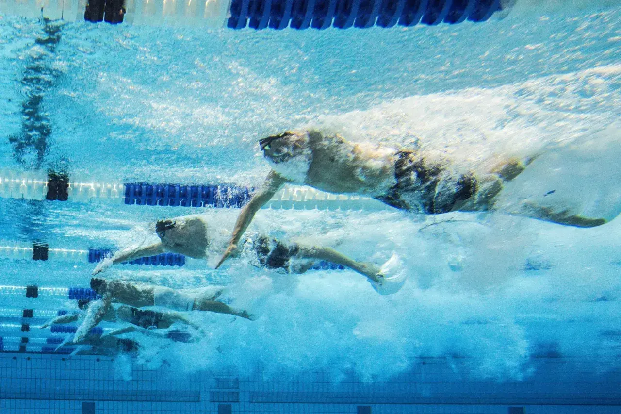 Nuotatori in gara, un'ispirazione per chi vuole imparare a nuotare. L'acqua turbolenta mostra la potenza e la velocità.