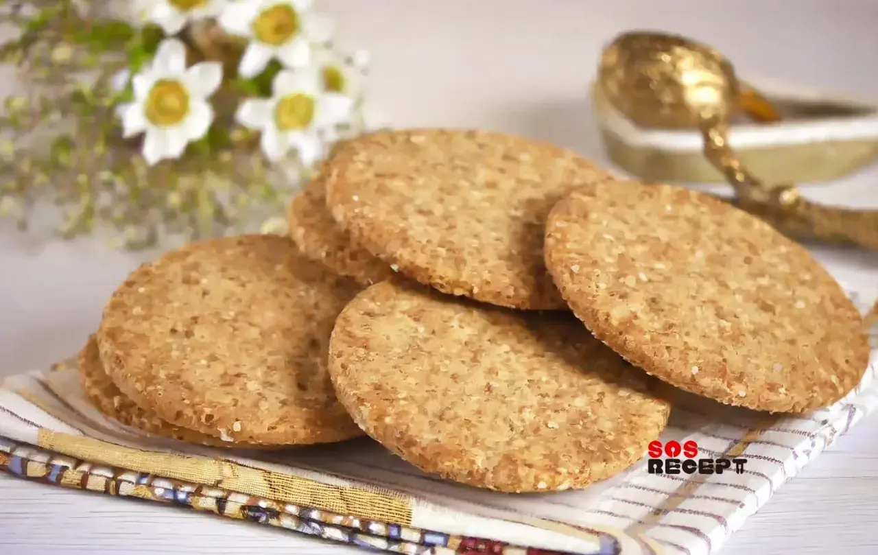 En hög med runda, gyllene digestivekex med sesamfrön. Perfekt för ett enkelt digestivekex recept.