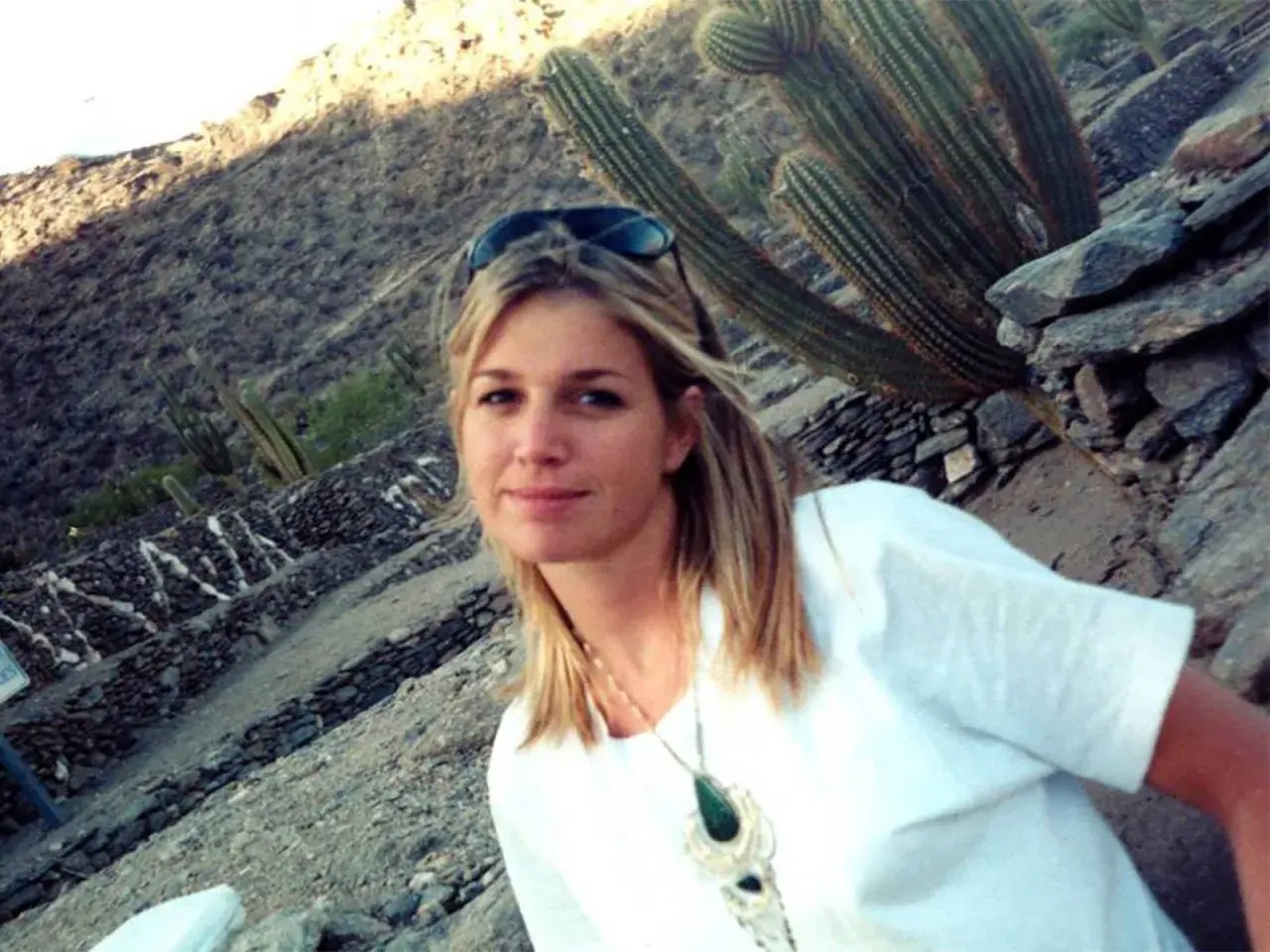 Máxima de Holanda joven sonríe en un paisaje desértico con cactus gigantes.