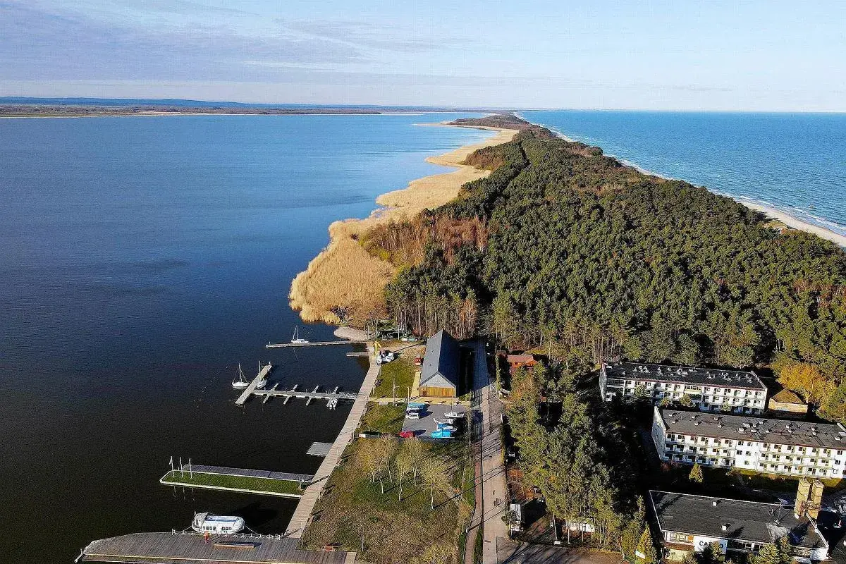 Dąbki atrakcje: malowniczy widok na jezioro, las, plażę i zabudowania. Idealne miejsce na wypoczynek.