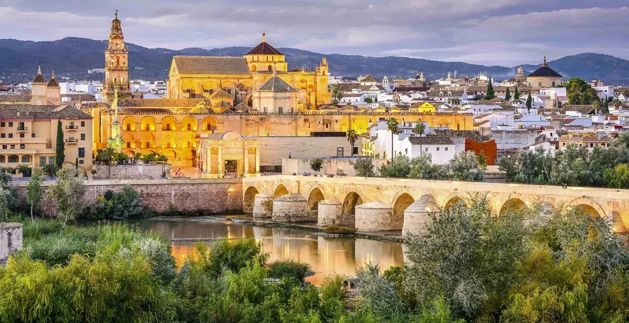 Puente Romano y Mezquita-Catedral de Córdoba, un ave que vuela sobre la historia, evocando un viaje desde Barcelona.