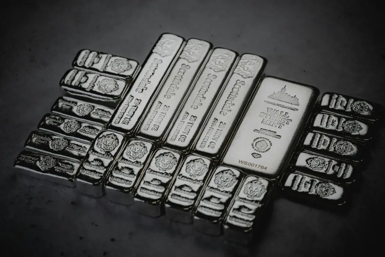 Mehrere Silberbarren, darunter Scottsdale 20 Troy oz und Wall Street Mint, glänzen im Licht.