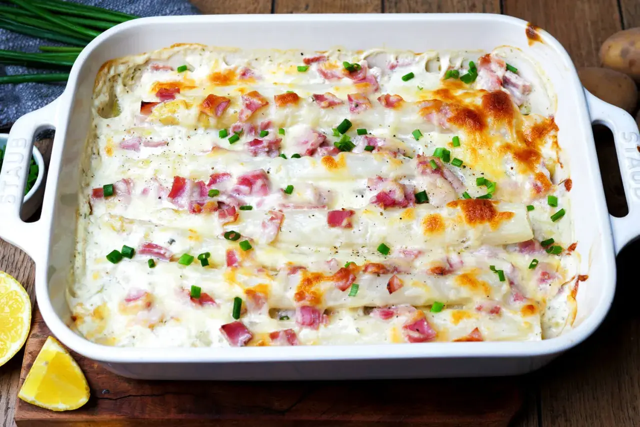 Ein köstlicher Spargel Kartoffel Auflauf mit Schinken und Käse überbacken, garniert mit Schnittlauch.