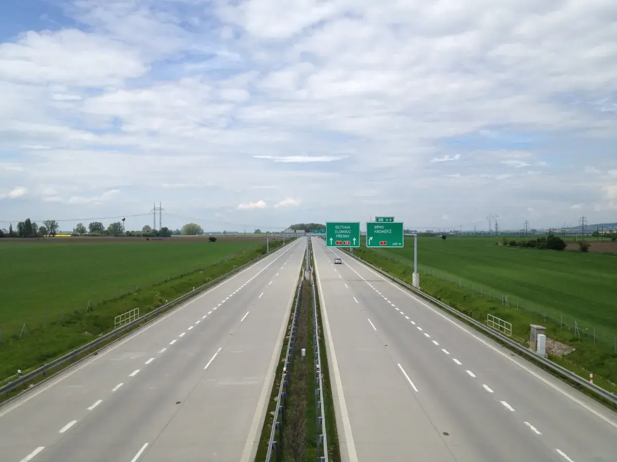 Autostrada w Czechach z zielonymi znakami drogowymi wskazującymi kierunki.
