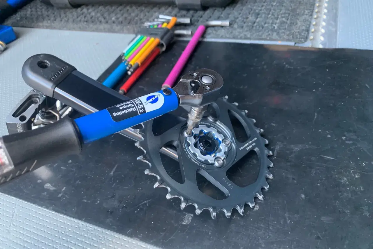 Using a Park Tool torque wrench to ensure proper SRAM chainring bolt torque for a bike repair.