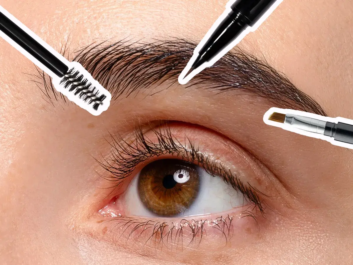 Occhio con ciglia lunghe e sopracciglia truccate, con pennelli per il make-up che definiscono lo sguardo.