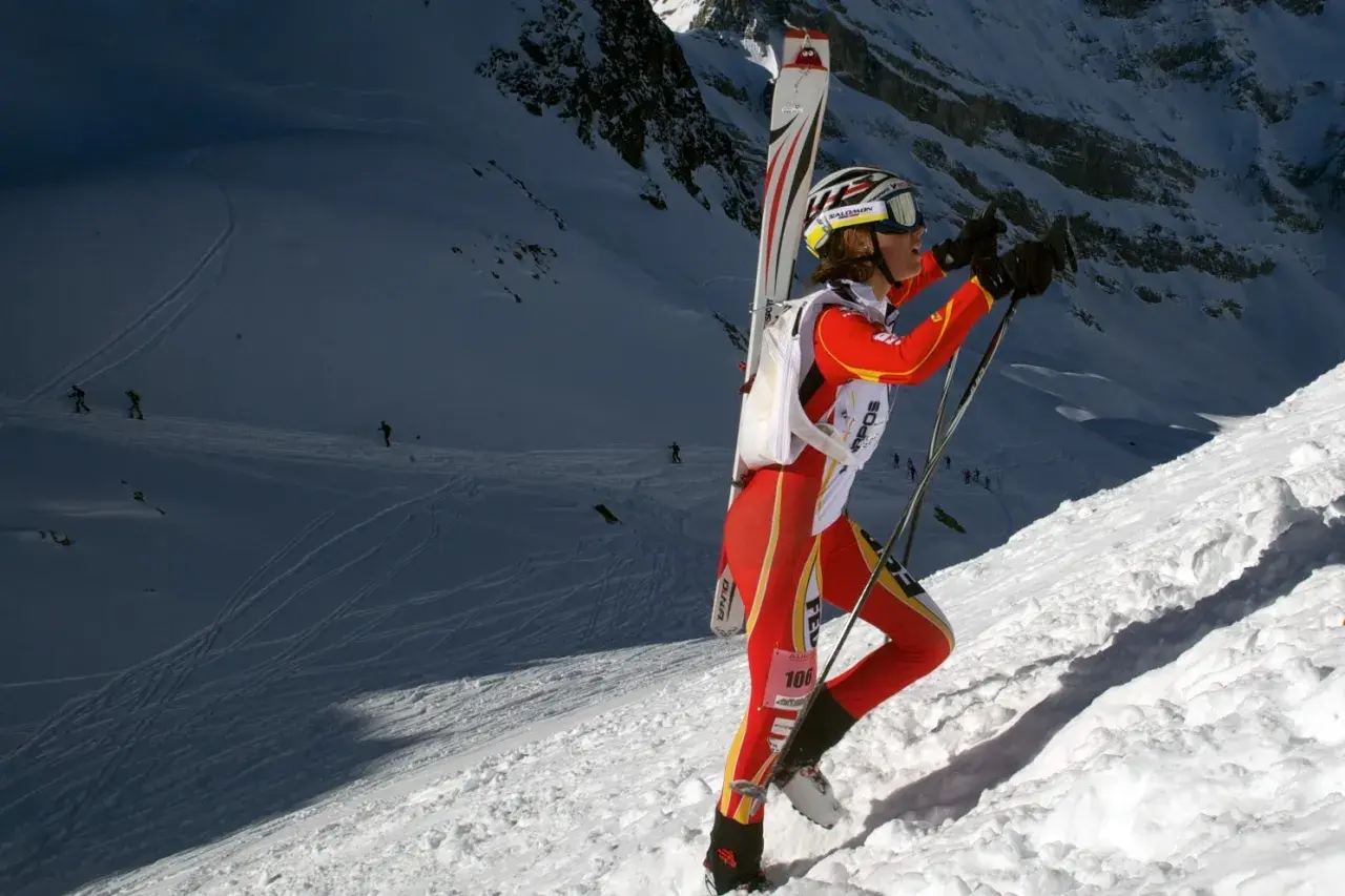 Mireia Miro, con esquís a la espalda, asciende una ladera nevada en una competición de esquí de montaña.