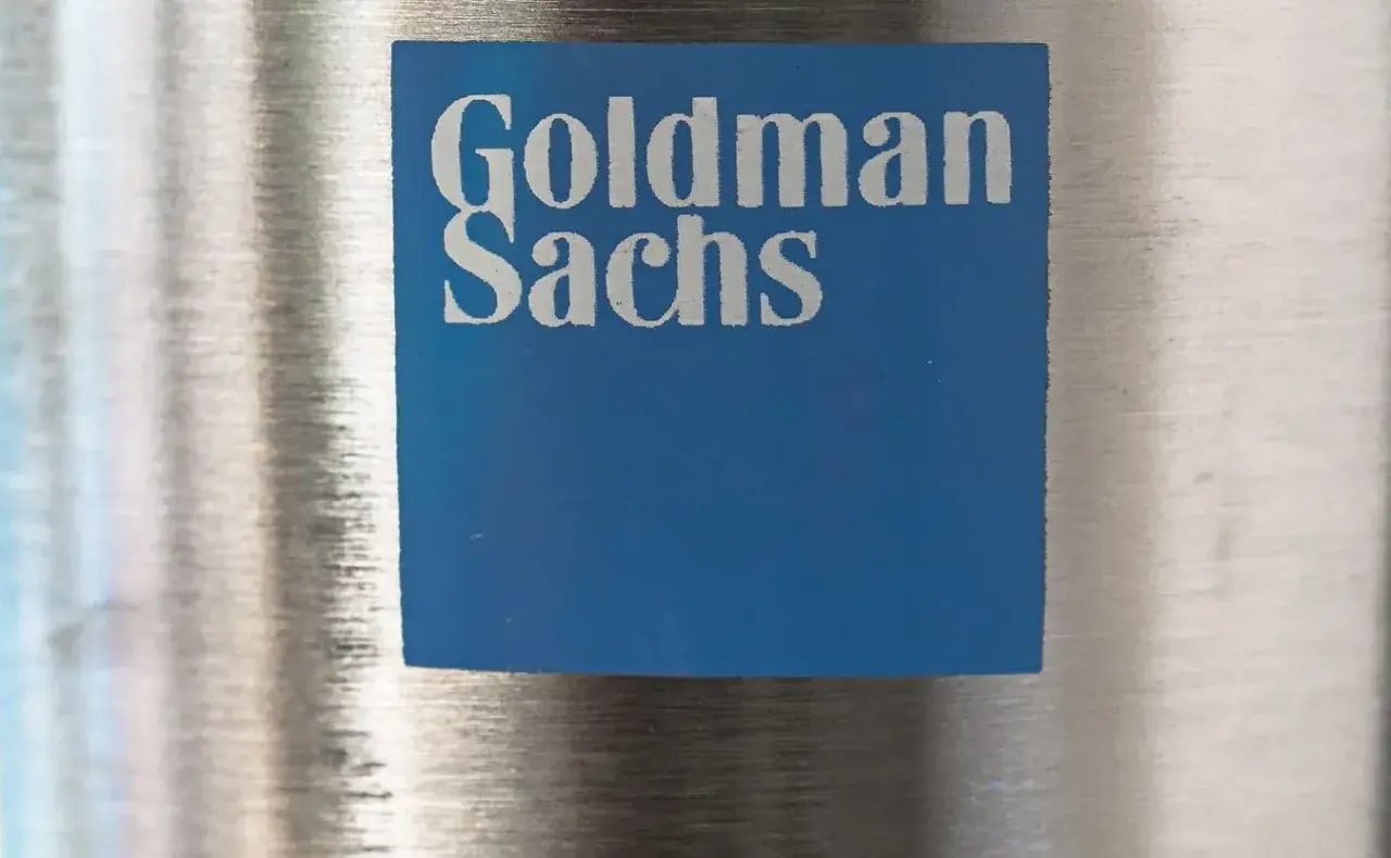 Niebieski kwadrat z logo Goldman Sachs, symbolizujący stabilny wzrost i pewność w świecie finansów.