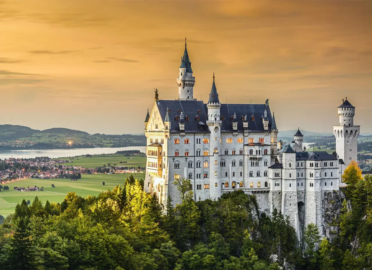 Bajkowy zamek Neuschwanstein, jeden z najpiękniejszych zamków w Europie, wznosi się na skale wśród drzew.