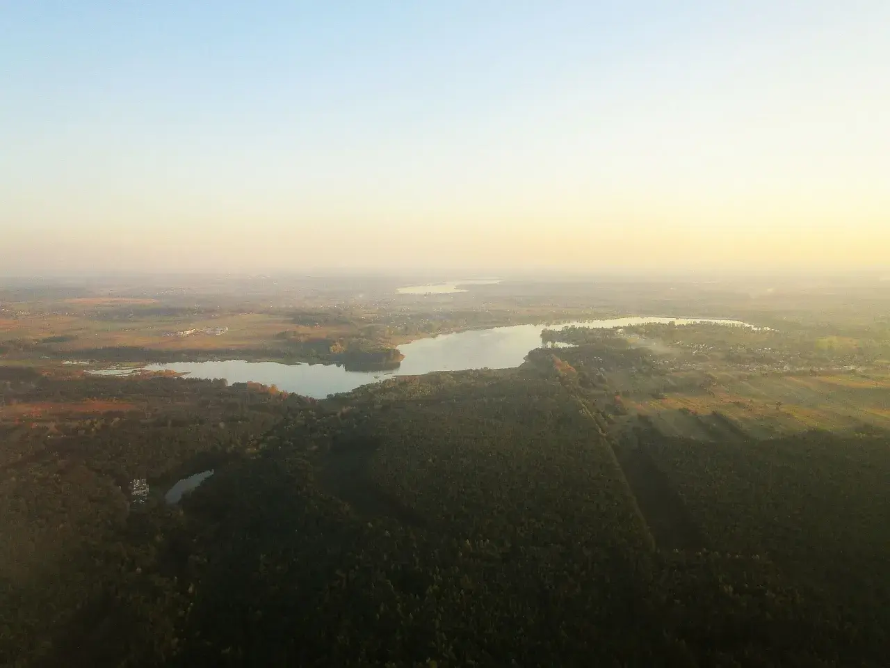 Widok z lotu ptaka na zalew przeczycko-siewierski otoczony lasami i polami.