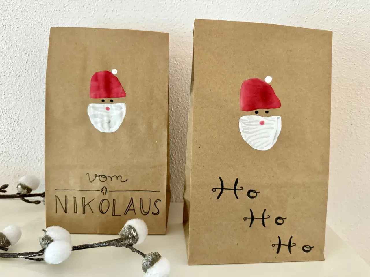 Zwei selbstgemachte Nikolauskarten aus Kraftpapier mit gemalten Nikolausgesichtern und Schriftzug "Vom Nikolaus" und "Ho Ho Ho".