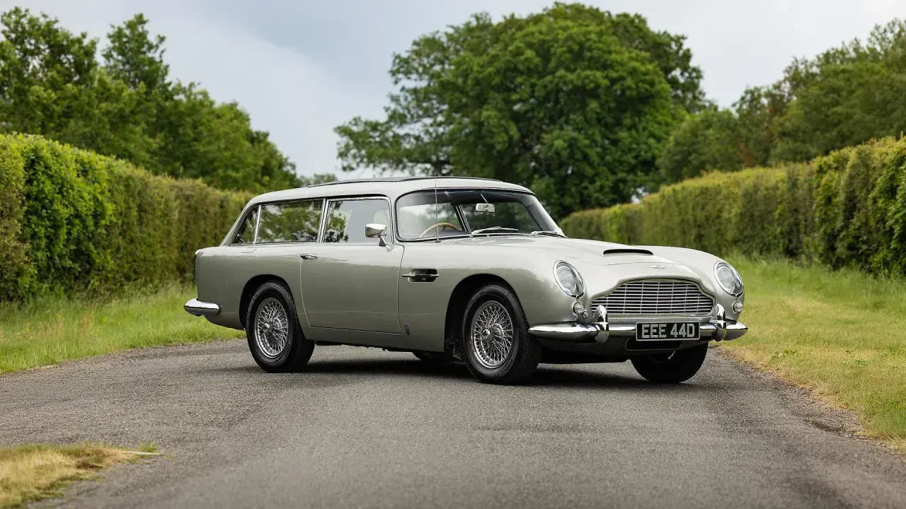 Srebrny Aston Martin DB5 Shooting Brake na tle zieleni. Klasyk z lat 60. w unikalnej wersji kombi.