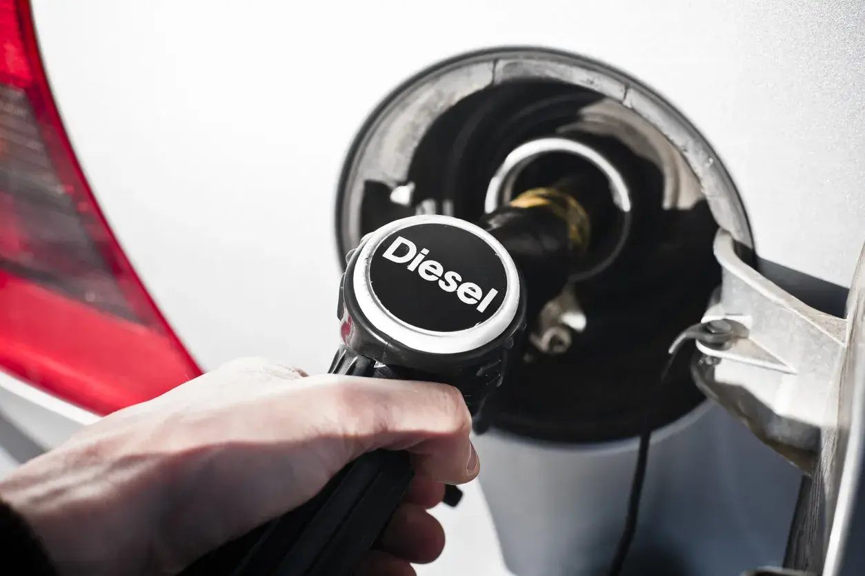 Mano che inserisce la pompa diesel nel serbatoio. Ci si interroga su euro 4 diesel fino a quando possono circolare.