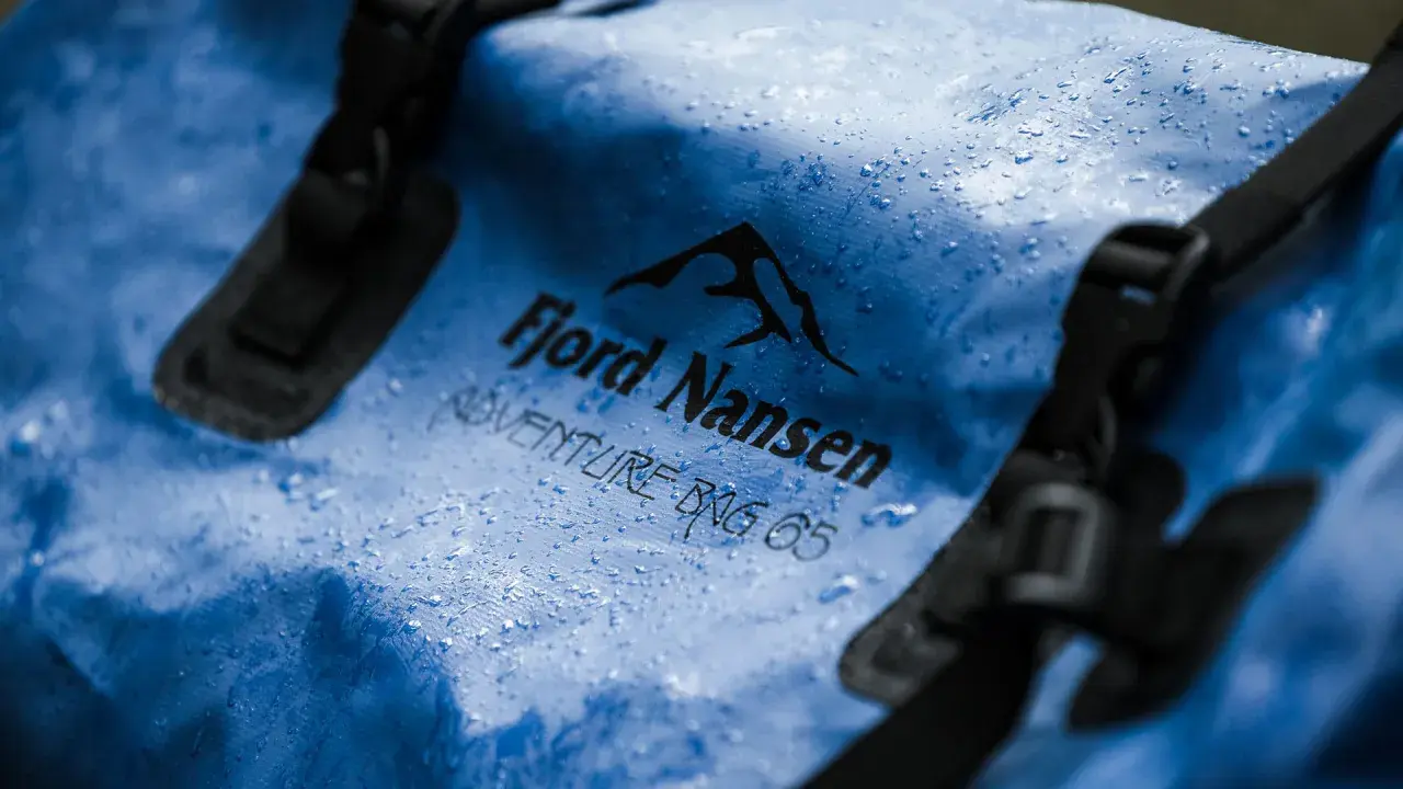 Niebieska torba Fjord Nansen Adventure Bag 65 z kropelkami wody. Waterproof to znaczy, że nic jej nie straszne.