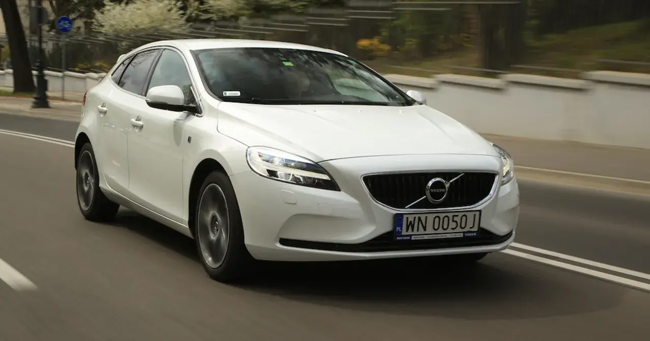 Białe Volvo V40 D2 w ruchu miejskim, z widocznym numerem rejestracyjnym WN 0050J.