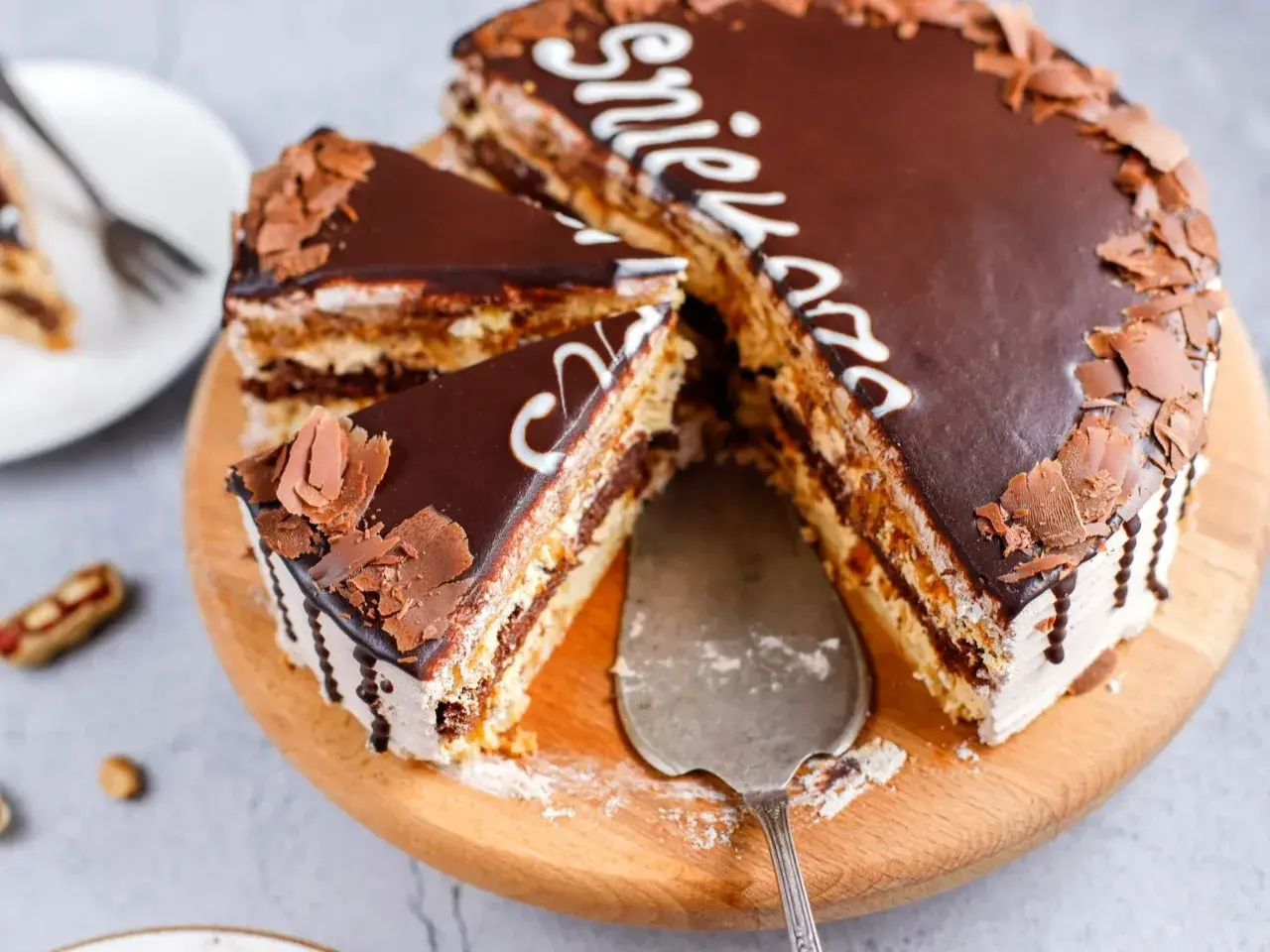 Pyszny tort snickers z czekoladą i orzeszkami, pokrojony na kawałki, gotowy do podania.
