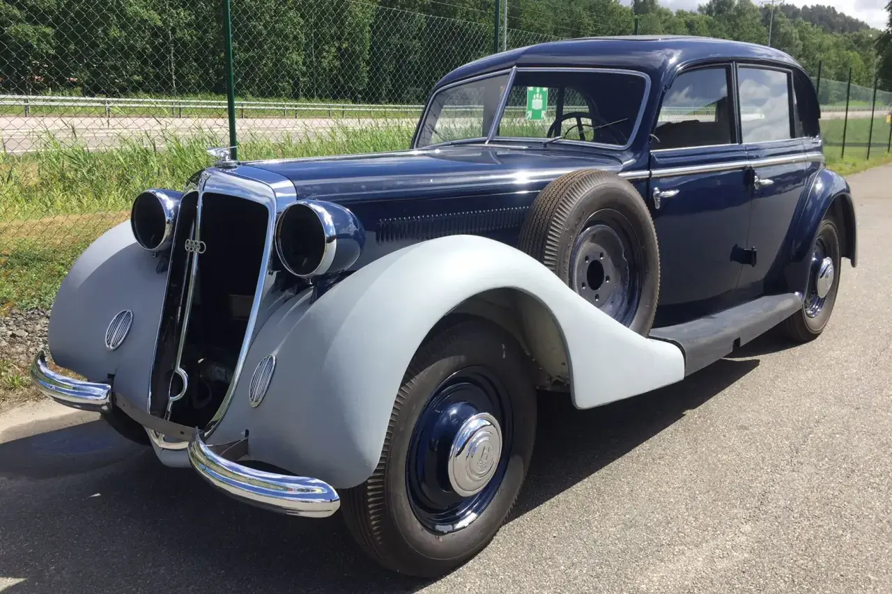 En mörkblå Horsch bil från 1930-talet med reservhjul på sidan.