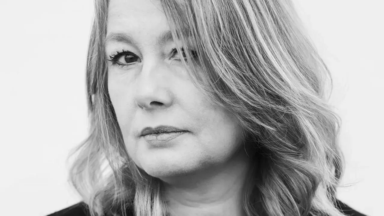Svartvitt porträtt av Åsa Linderborg, med fokus på hennes ansikte och blonda hår som faller över axeln.