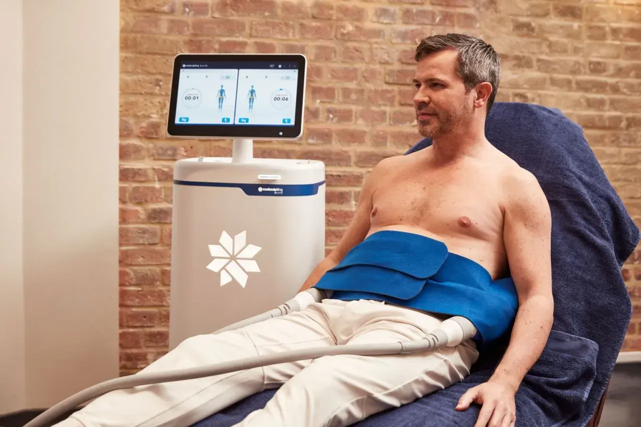Man får behandling med CoolSculpting för att reducera fett på magen.