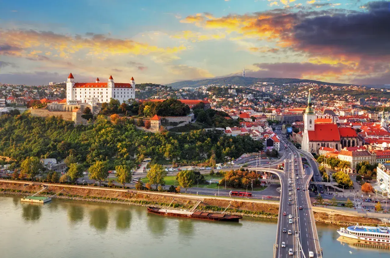 Bratysława czy warto? Widok na zamek i miasto nad Dunajem o zachodzie słońca.