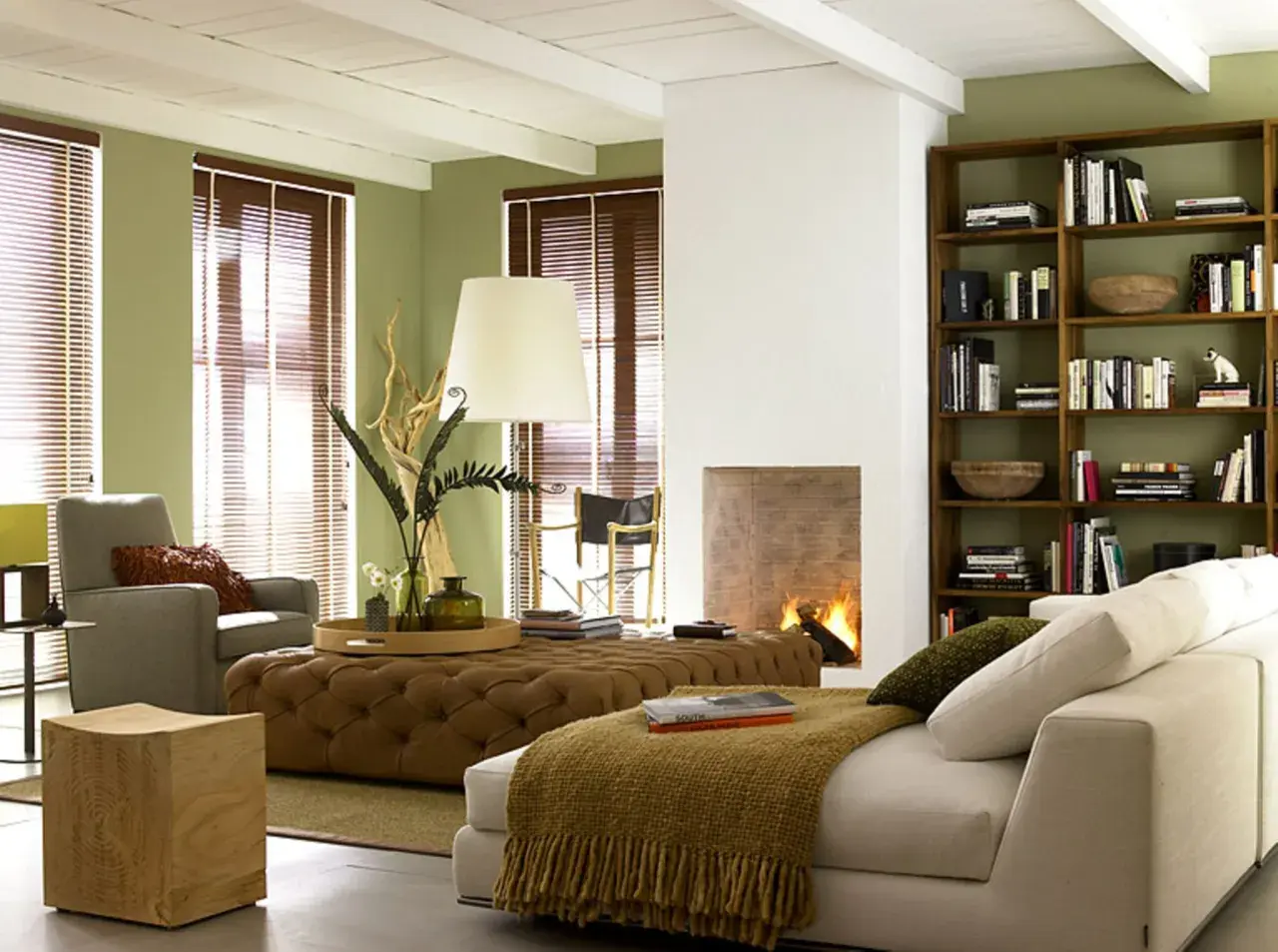 Gemütliches Wohnzimmer im kolonial stil mit Kamin, Bücherregal und bequemen Sitzmöbeln.