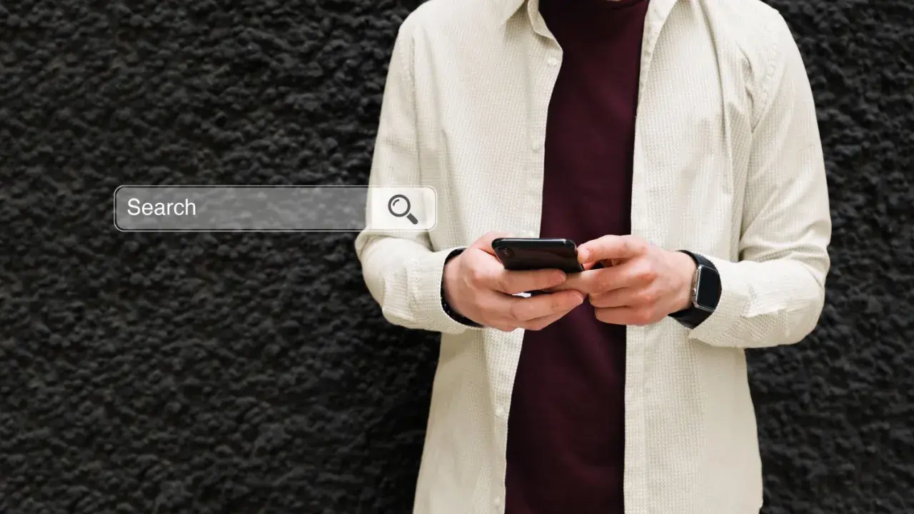 Mężczyzna z telefonem szuka w sieci informacji, jak włączyć Google Discover.