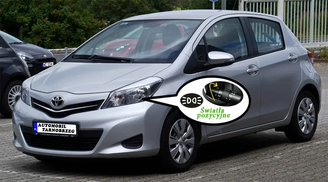 Srebrny Toyota Yaris z włączonymi światłami pozycyjnymi. Pokazano przełącznik świateł.