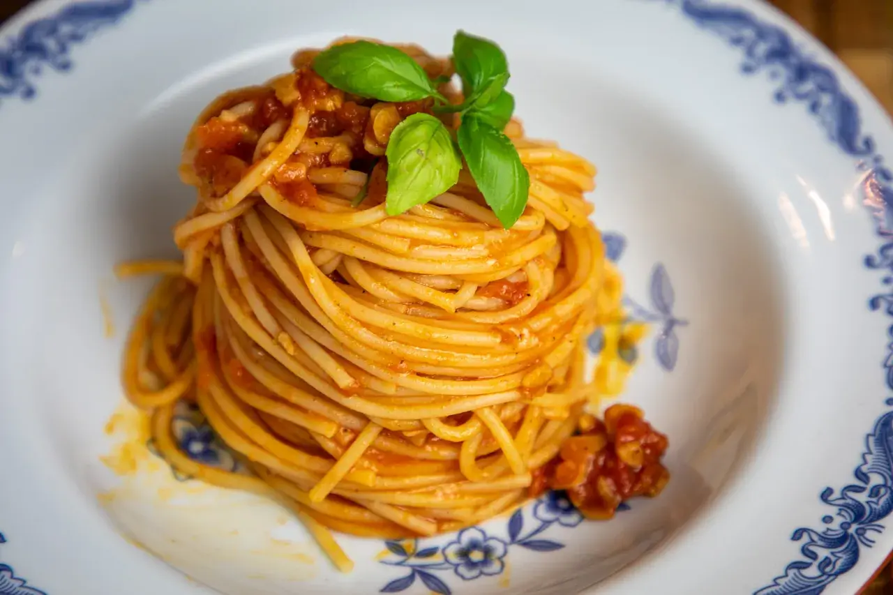 En portion spaghetti med en smakrik tomatsås, perfekt för ett enkelt pasta pomodoro recept. Garnerad med färsk basilika.