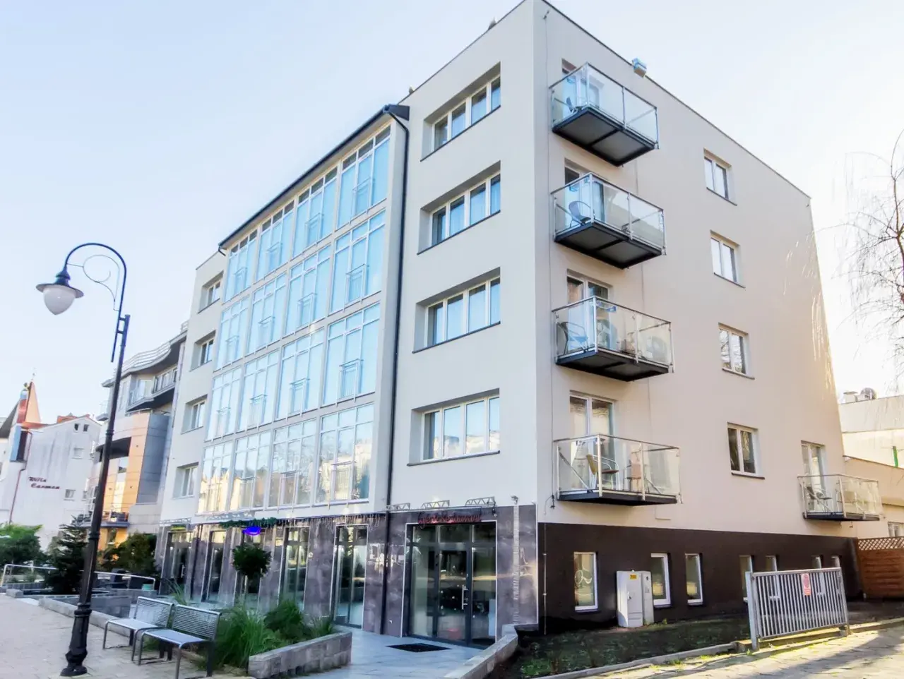 Nowoczesny hotel Lazur Świnoujście z przeszkloną fasadą i balkonami.