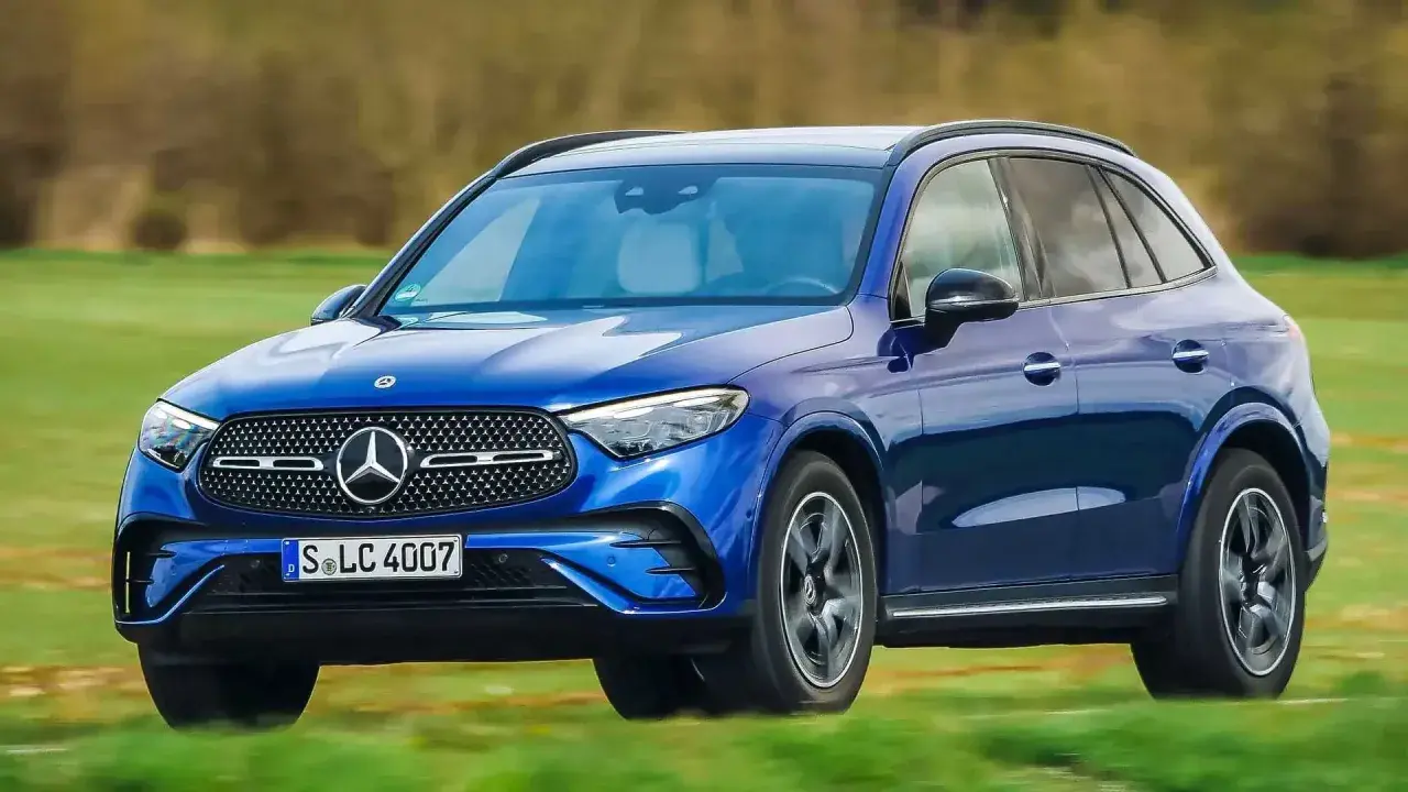 Blauer Mercedes-Benz GLC 300e PS fährt auf einer grünen Wiese.