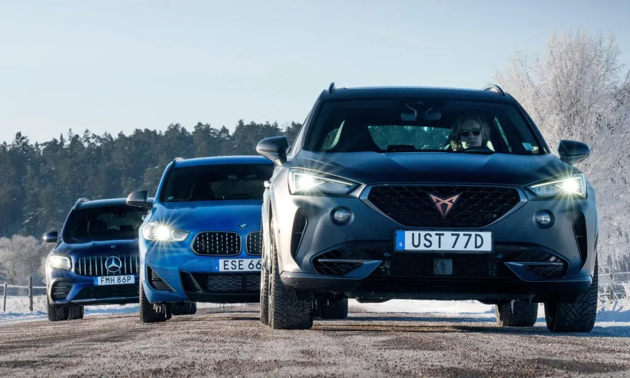 Tre SUV:ar, en mörkgrå Cupra, en blå BMW och en mörkblå Mercedes, kör på en snöig väg. AWD betyder att alla hjulen driver, perfekt för vinterväglag.