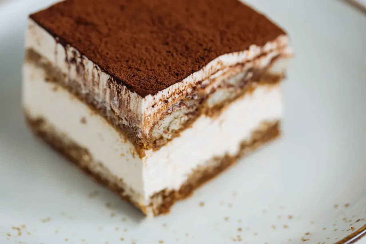 Un délicieux tiramisu chocolat, avec ses couches crémeuses et sa poudre de cacao, prêt à être dégusté.