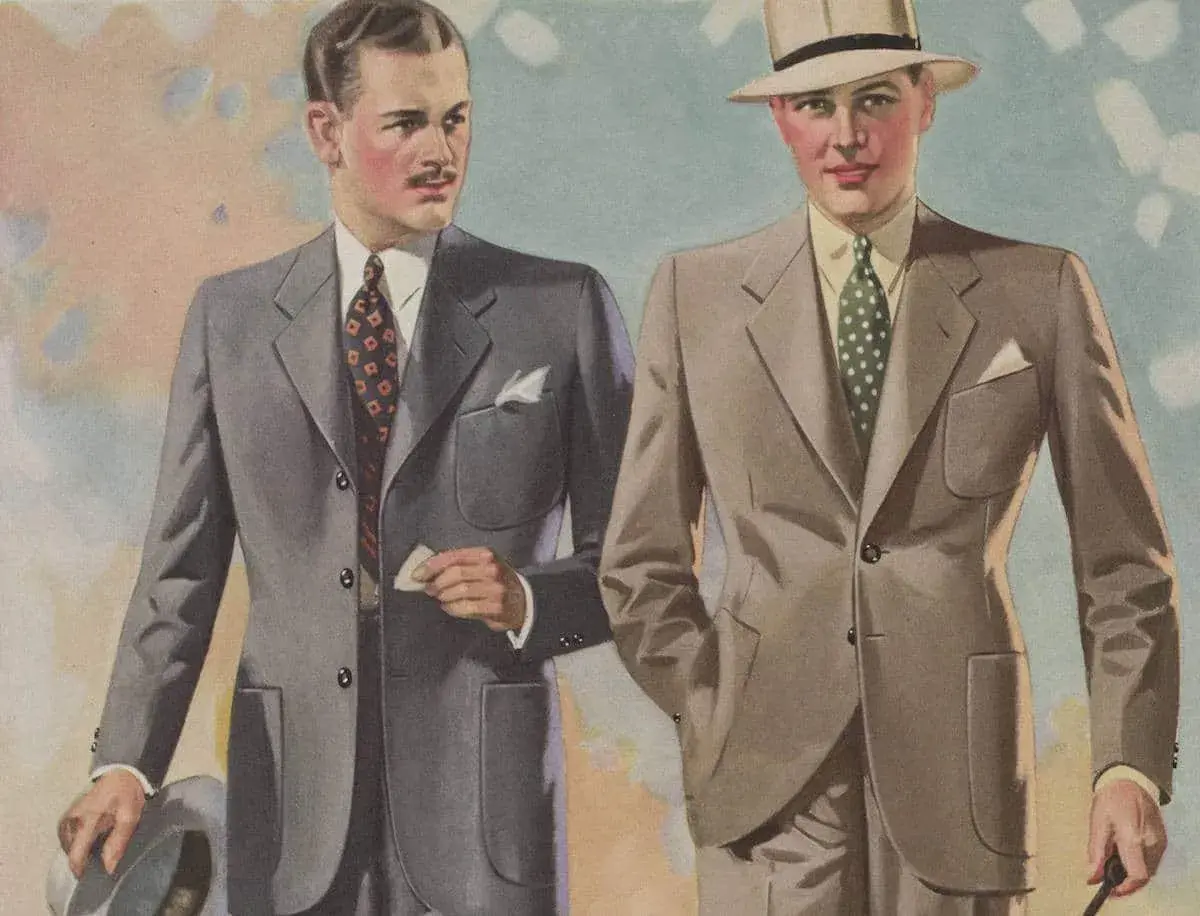 Två män i stilfulla kostymer, en grå och en beige, med hattar och slipsar. En tidlös mode 30 tal-stil.