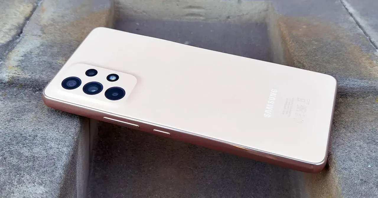 Różowy Samsung A53 z aparatem na kamiennym tle.