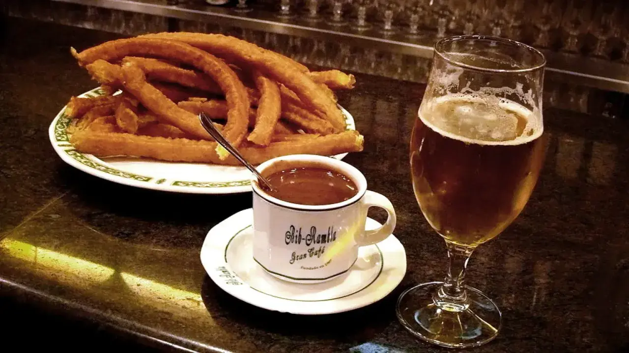 Churros con chocolate y una cerveza, cosas típicas de España.