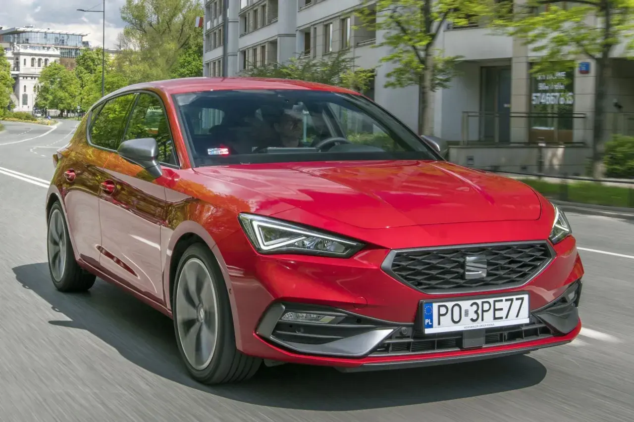 Czerwony SEAT Leon 4 w ruchu miejskim.