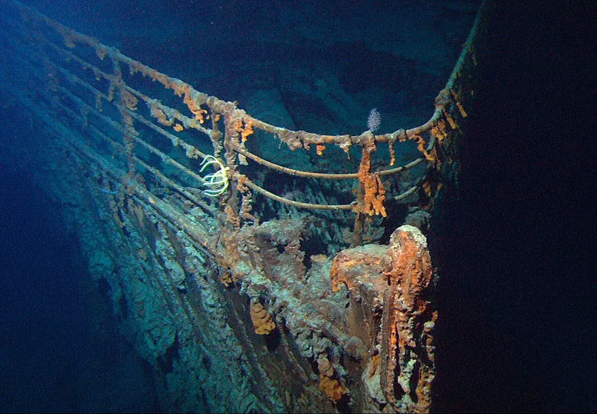 Det rostiga Titanic vraket på havets botten. En vit, tentakelliknande varelse har fäst sig vid räcket.