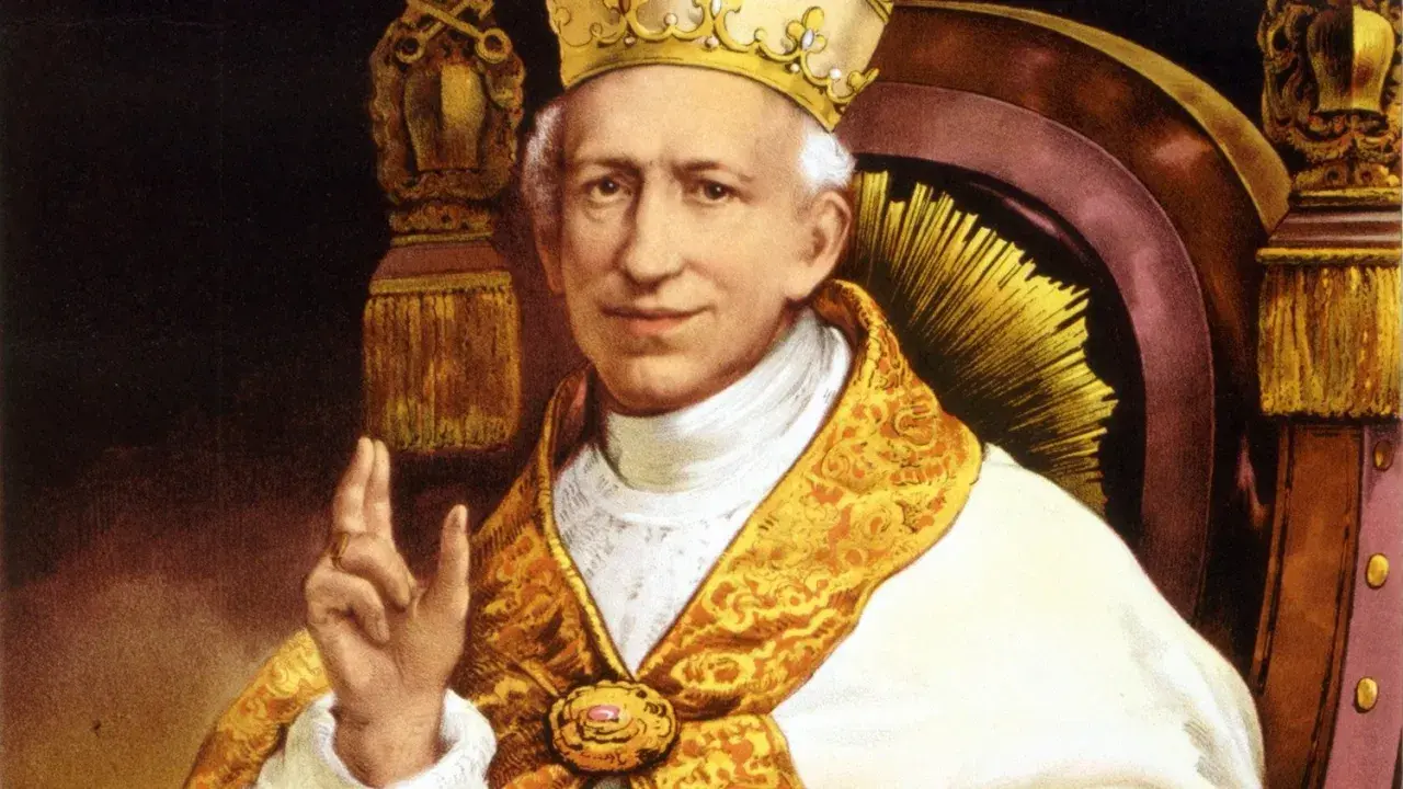 Portret papieża Leona XIII w bogatych szatach i tiarze, błogosławiący gestem dłoni.