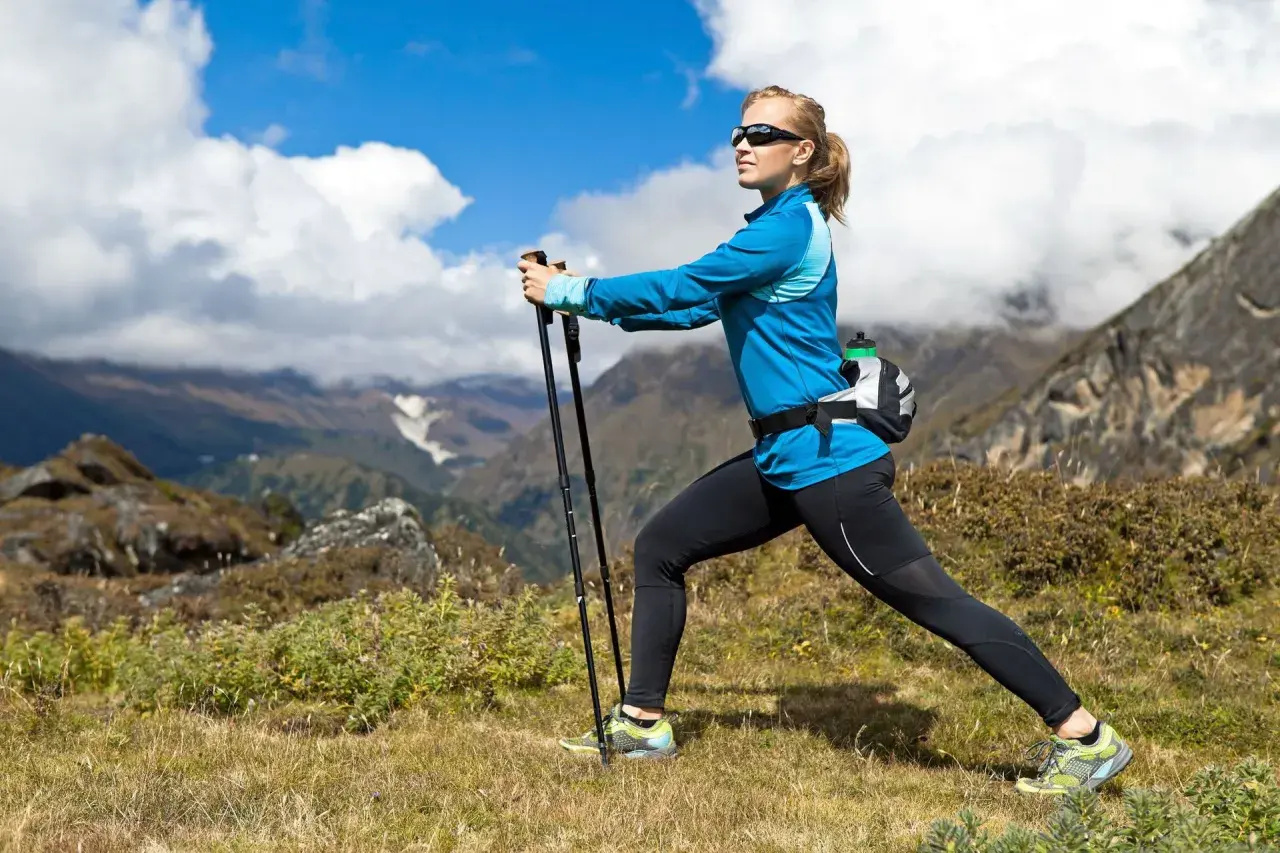 Kobieta ćwiczy nordic walking w górach. Po miesiącu regularnych treningów widać pierwsze efekty: lepszą kondycję i smuklejszą sylwetkę.