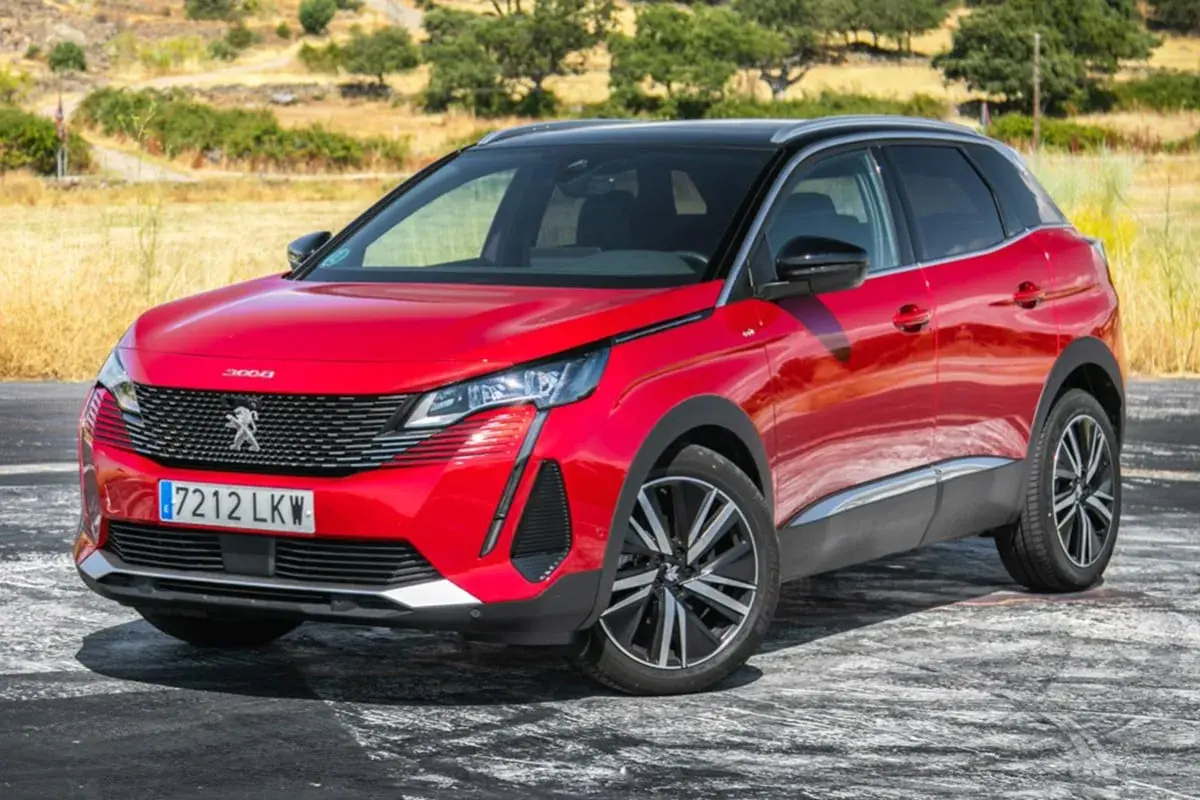 Opiniones del motor Peugeot 3008 1.5 HDI 130 CV: SUV rojo brillante aparcado en un camino rural con vegetación seca al fondo.