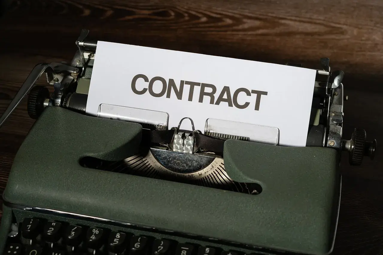 Stara maszyna do pisania z kartką z napisem "CONTRACT". Czas na wypowiedzenie umowy B2B.