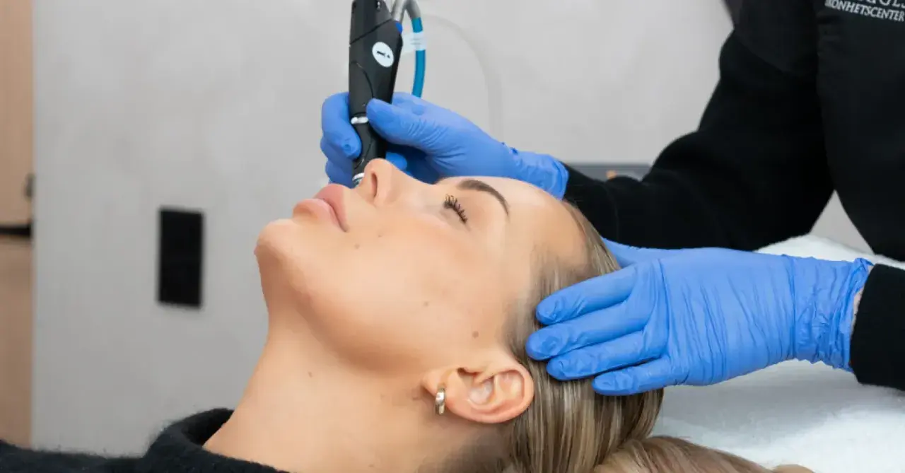 En kvinna får ansiktsbehandling med en fractional CO2 laser för hudförbättring.