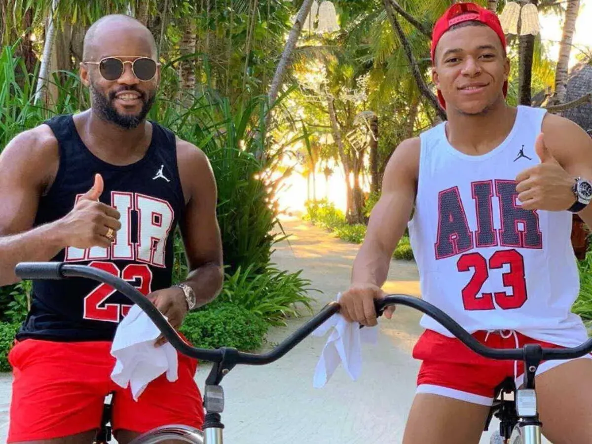 Brat Kyliana Mbappé, Ethan, w czarnej koszulce i czerwonych spodenkach, pozuje do zdjęcia z bratem, Kylianem, w białej koszulce i czerwonych spodenkach.
