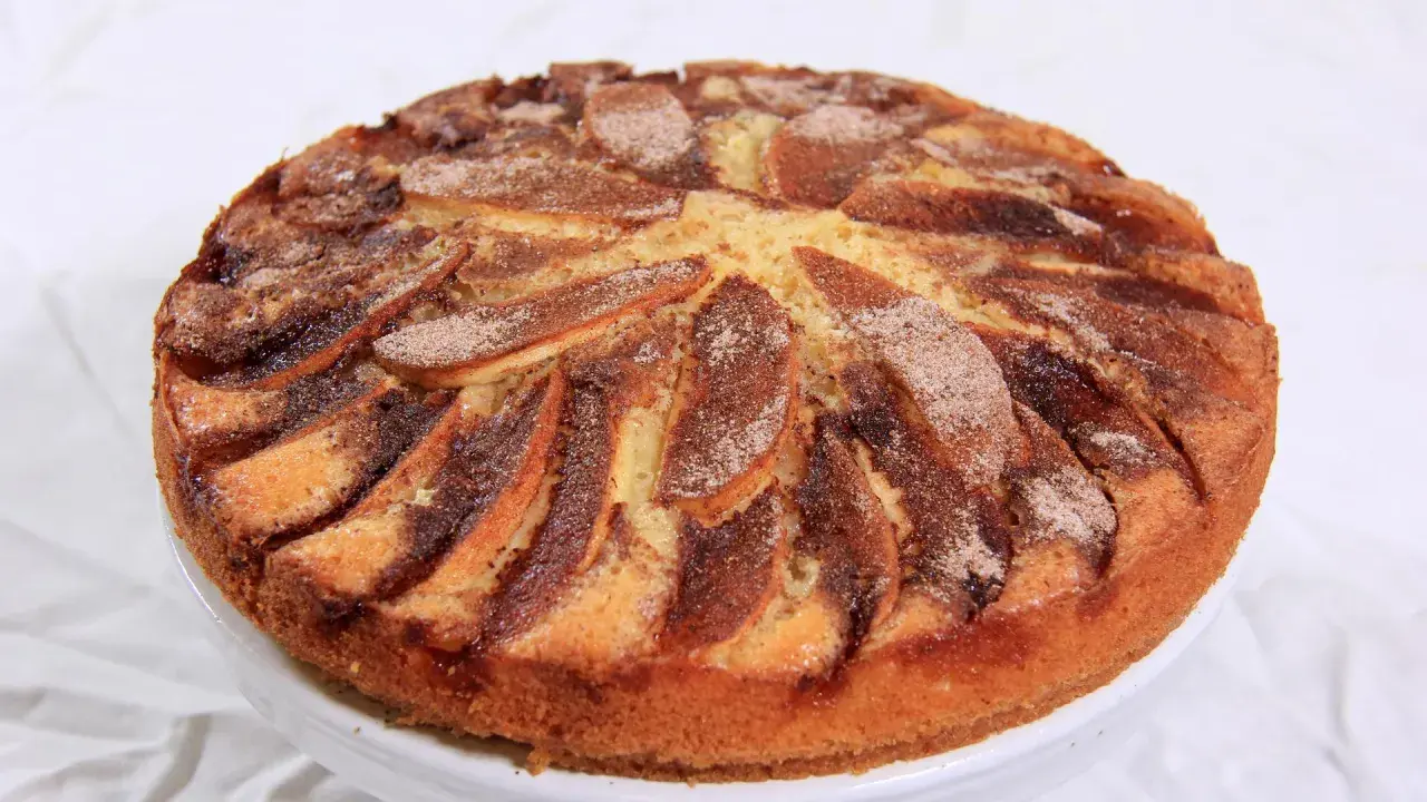 En saftig torta di mele, med äppelklyftor och kanel, redo att avnjutas.